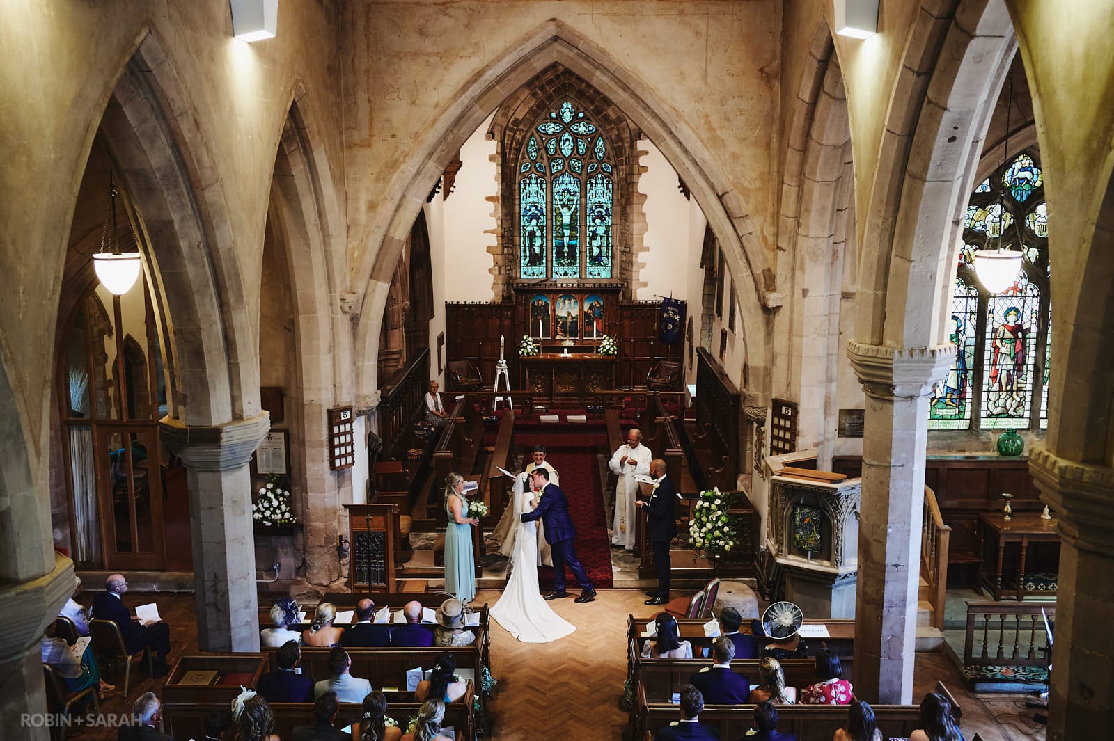 Bride and groom kiss during wedding ceremony at St Peter's church Dunchurch