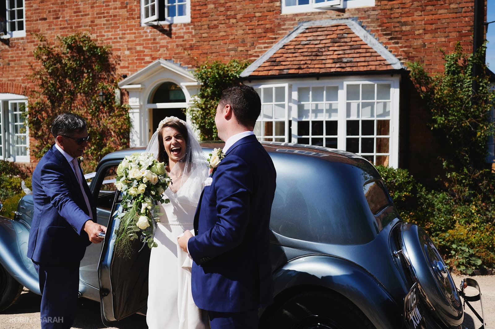 Bride laughing as she arrives with groom at Wethele Manor for wedding reception