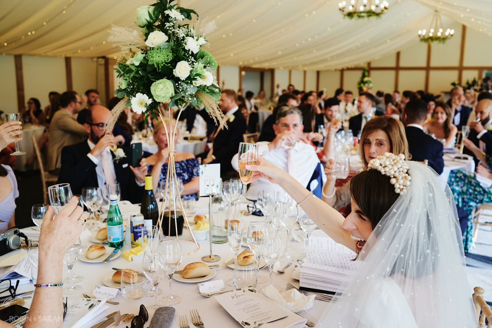 Bride and guests raise a glass during wedding speeches