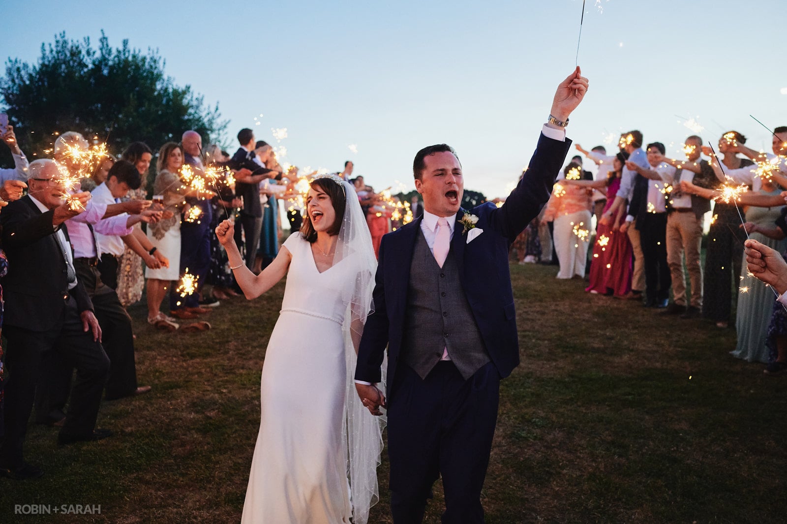 Bride and groom walk through sparklers at Wethele Manor