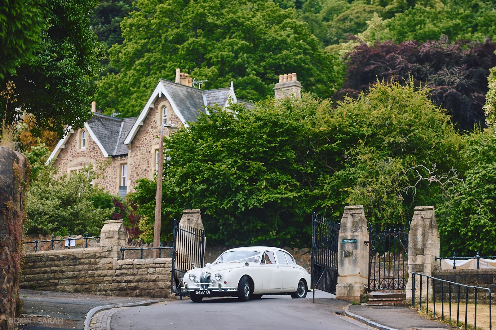 Bride's old Jaguar car arrives at Malvern College for wedding ceremony