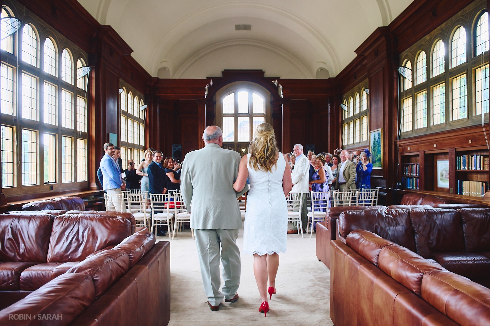 View from rear of Bride and dad walking up aisle for wedding ceremony in Malvern College Memorial Library