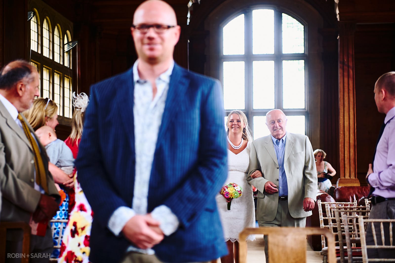 Bride and dad walk up aisle for wedding ceremony in Malvern College Memorial Library