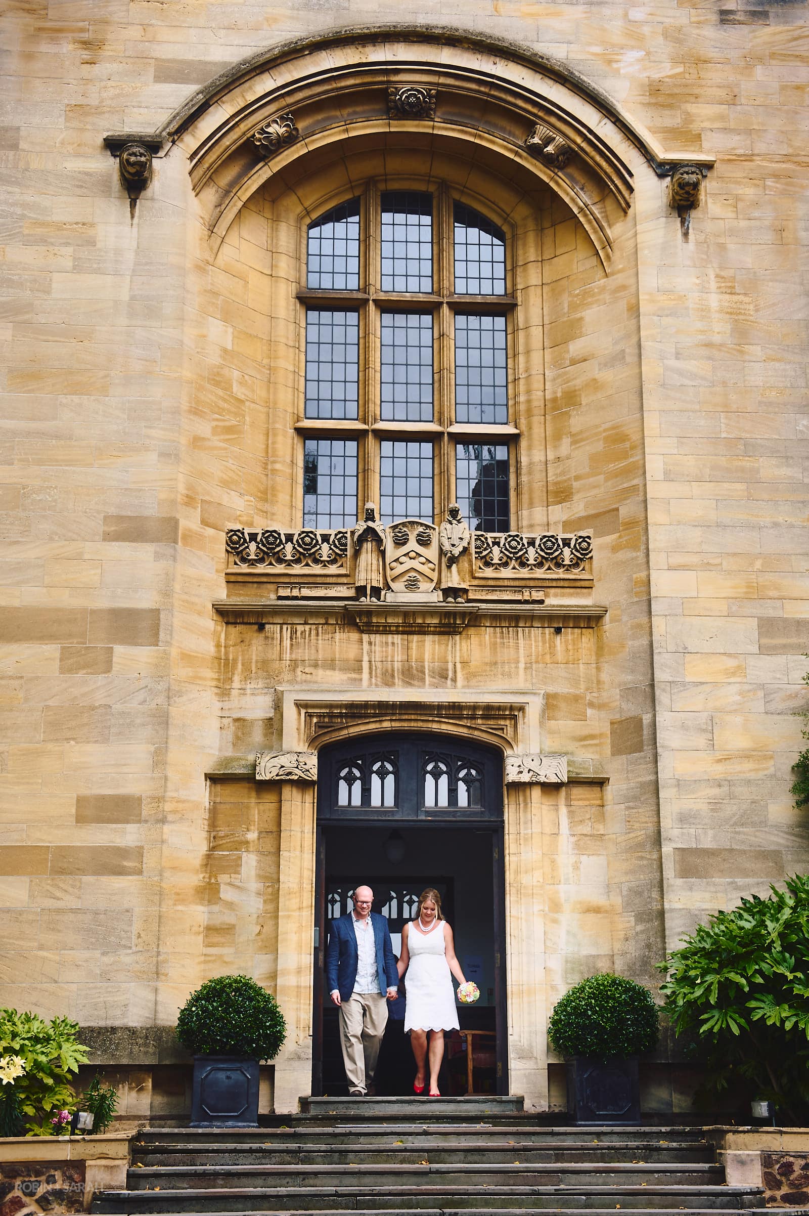 Bride and groom walk out of Malvern College Memorial Library after civil wedding ceremony