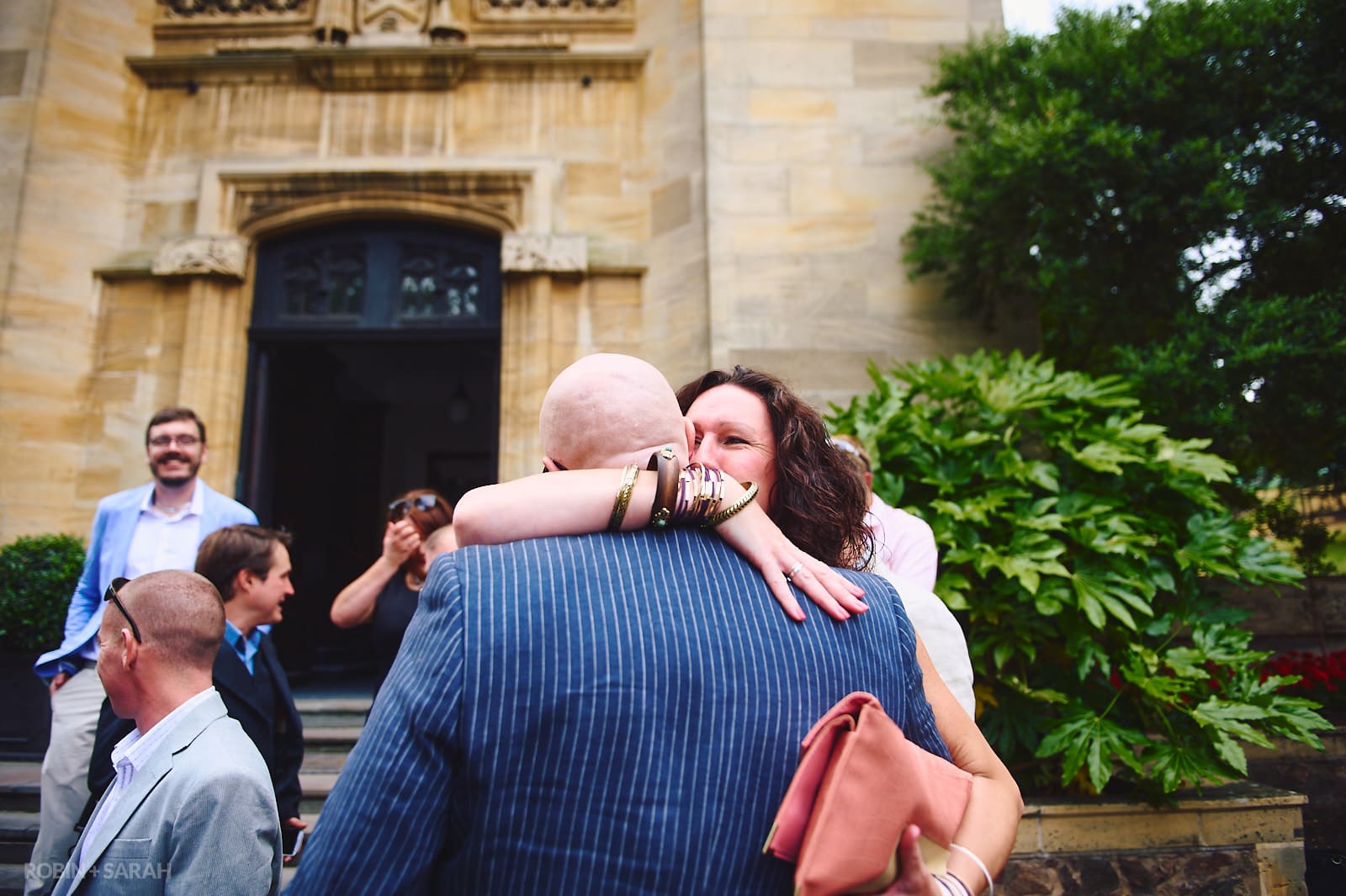 Wedding guests congratulate couple outside Malvern College Memorial Library