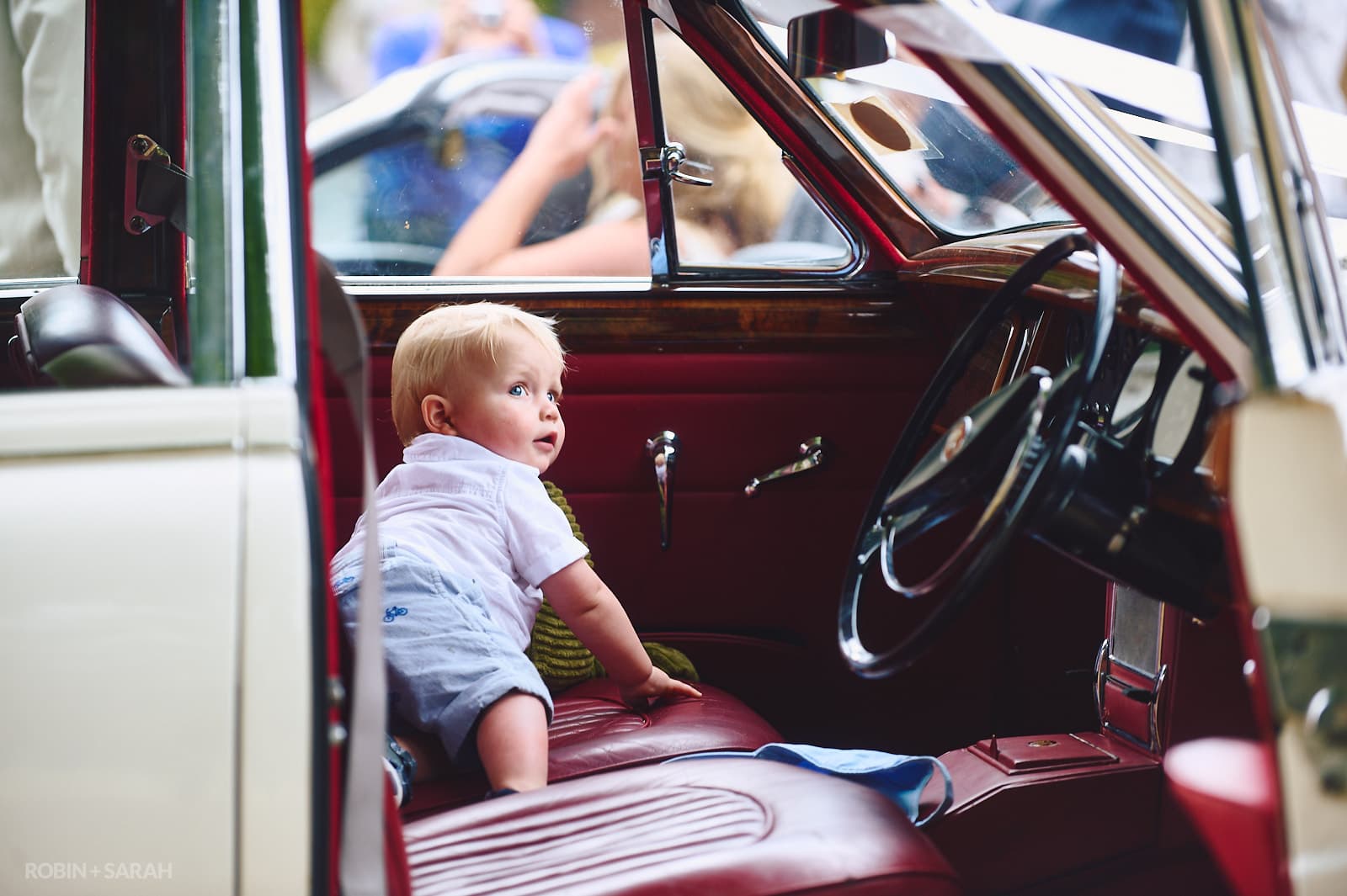 Toddler explorers interior of old Jaguar car