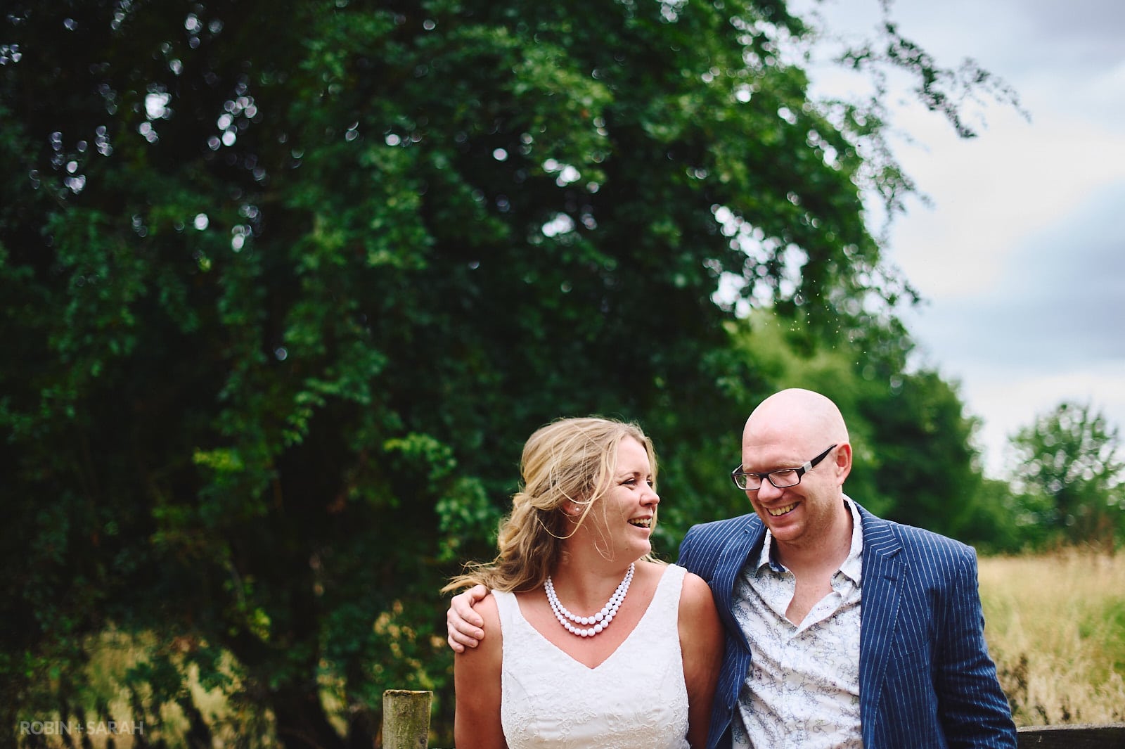 Bride and groom laughing together in beautiful gardens