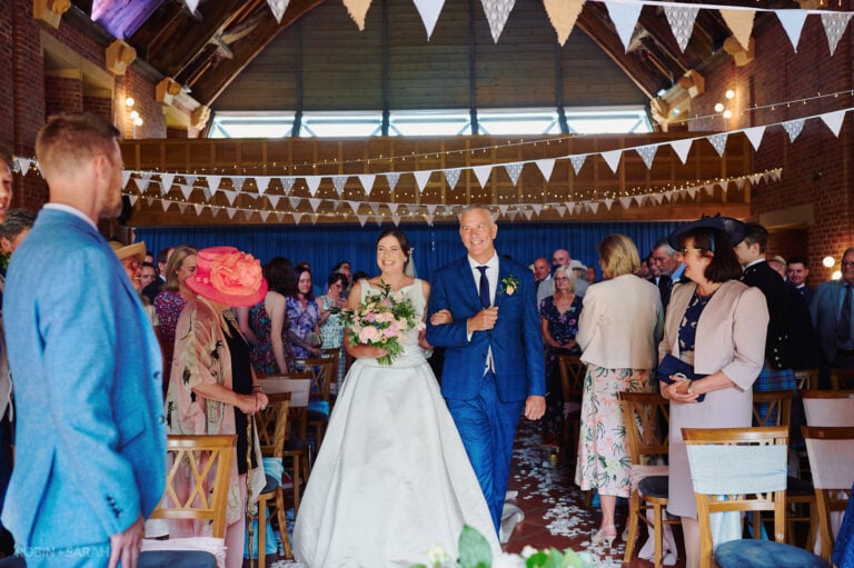 Bride walks up aisle during wedding ceremony at Avoncroft Museum