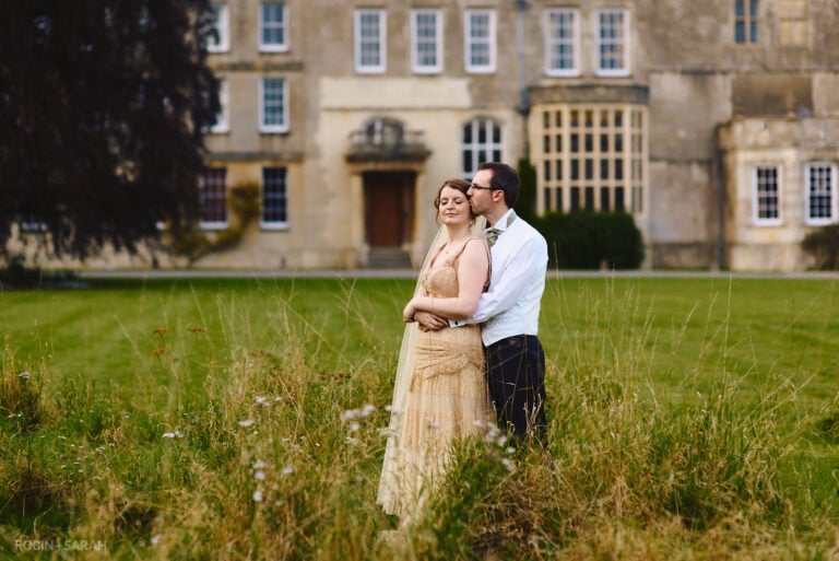 Bride and groom on lawn with Elmore Court in background