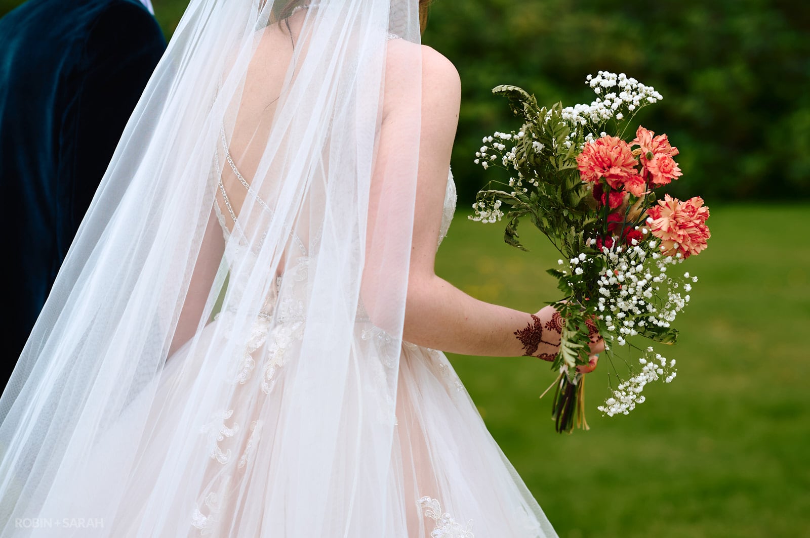 Detail of bride's bouquet as she walks through gardens
