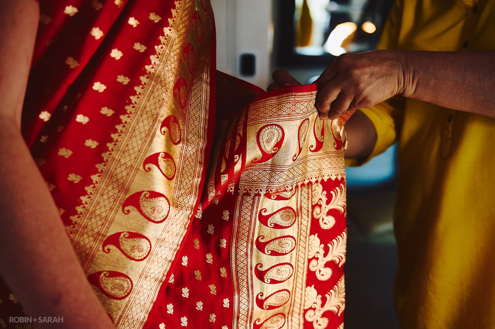 Bride gets help with putting on Indian wedding saree