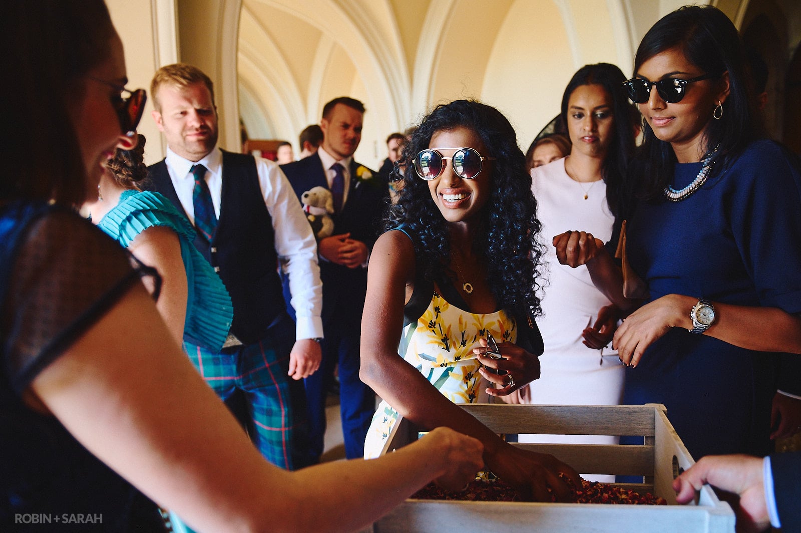 Wedding guests pick up handful of confetti after wedding ceremony