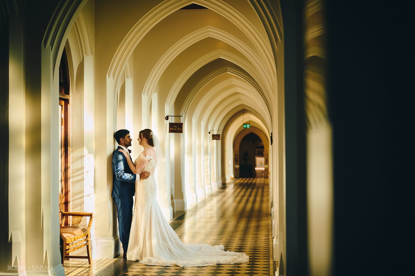 Bride and groom share a quiet moment together in cloister corridor at Stanbrook Abbey