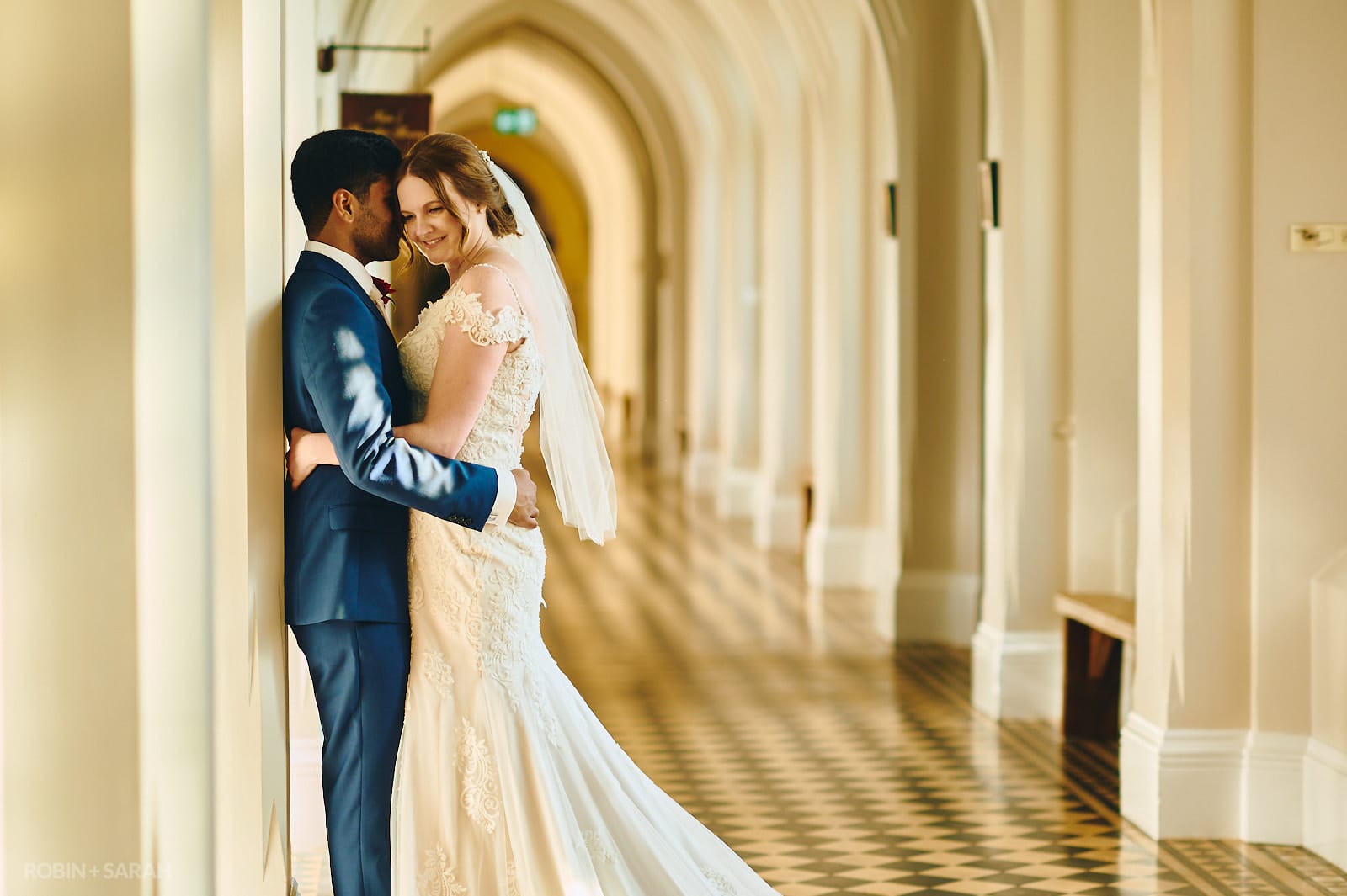 Bride and groom share a quiet moment together in cloister corridor at Stanbrook Abbey