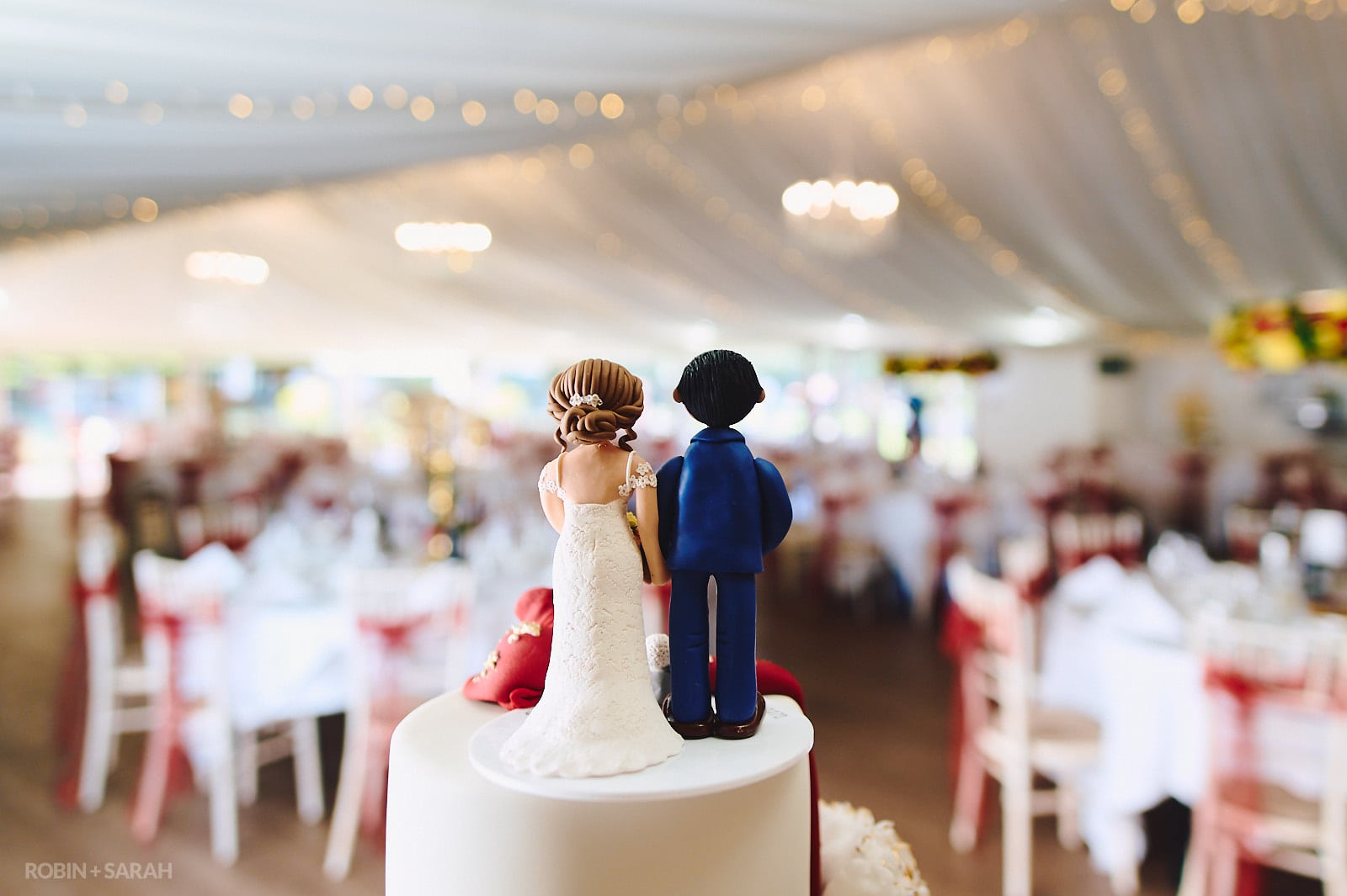 Rear of cake topper with view of marquee