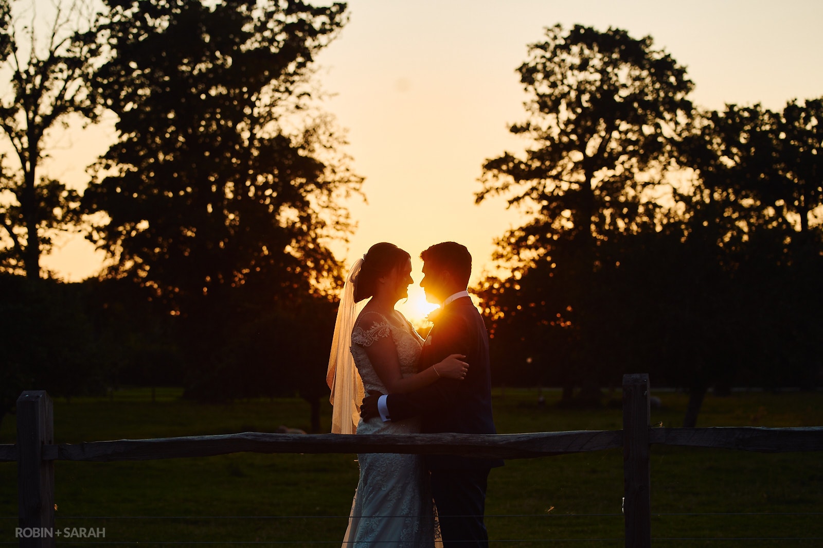 Bride and groom in grounds at Stanbrook Abbey with a beautiful sunset