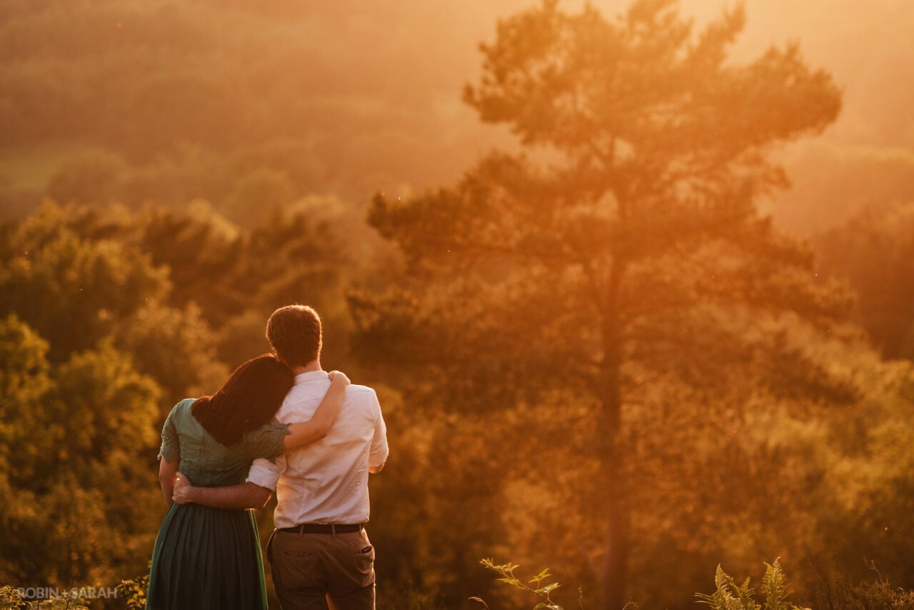 Engaged couple looking out over sunset