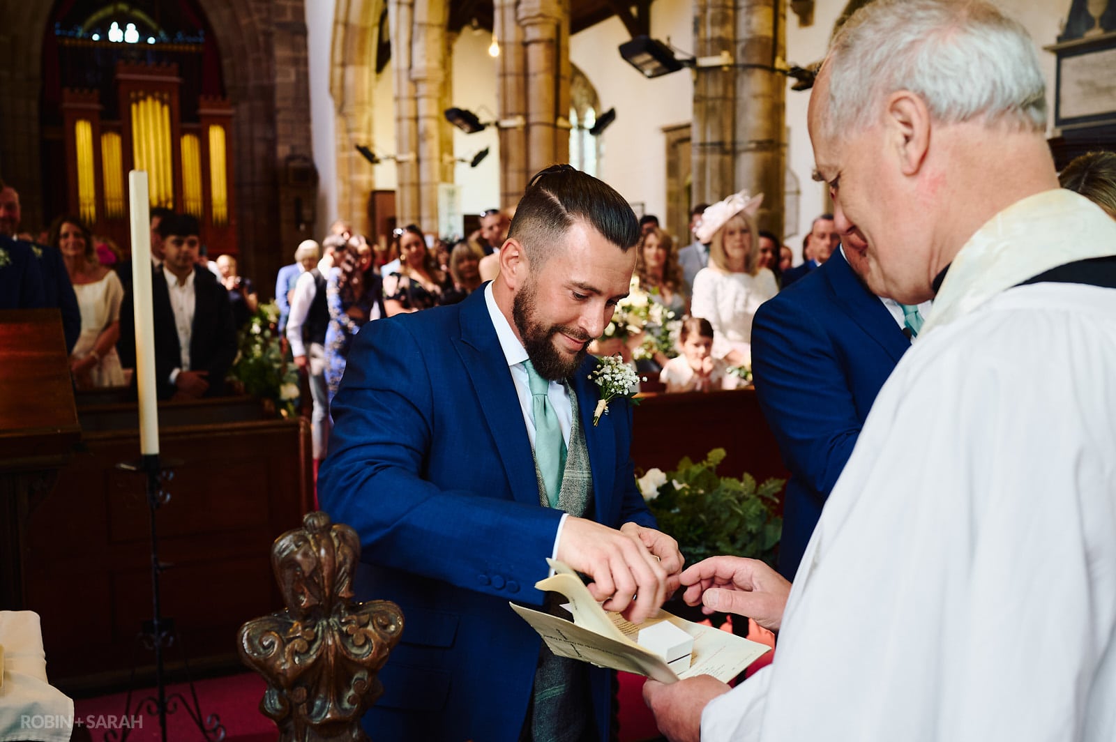 Best man hands wedding rings over to vicar at St Botolph's church Newbold-on-Avon