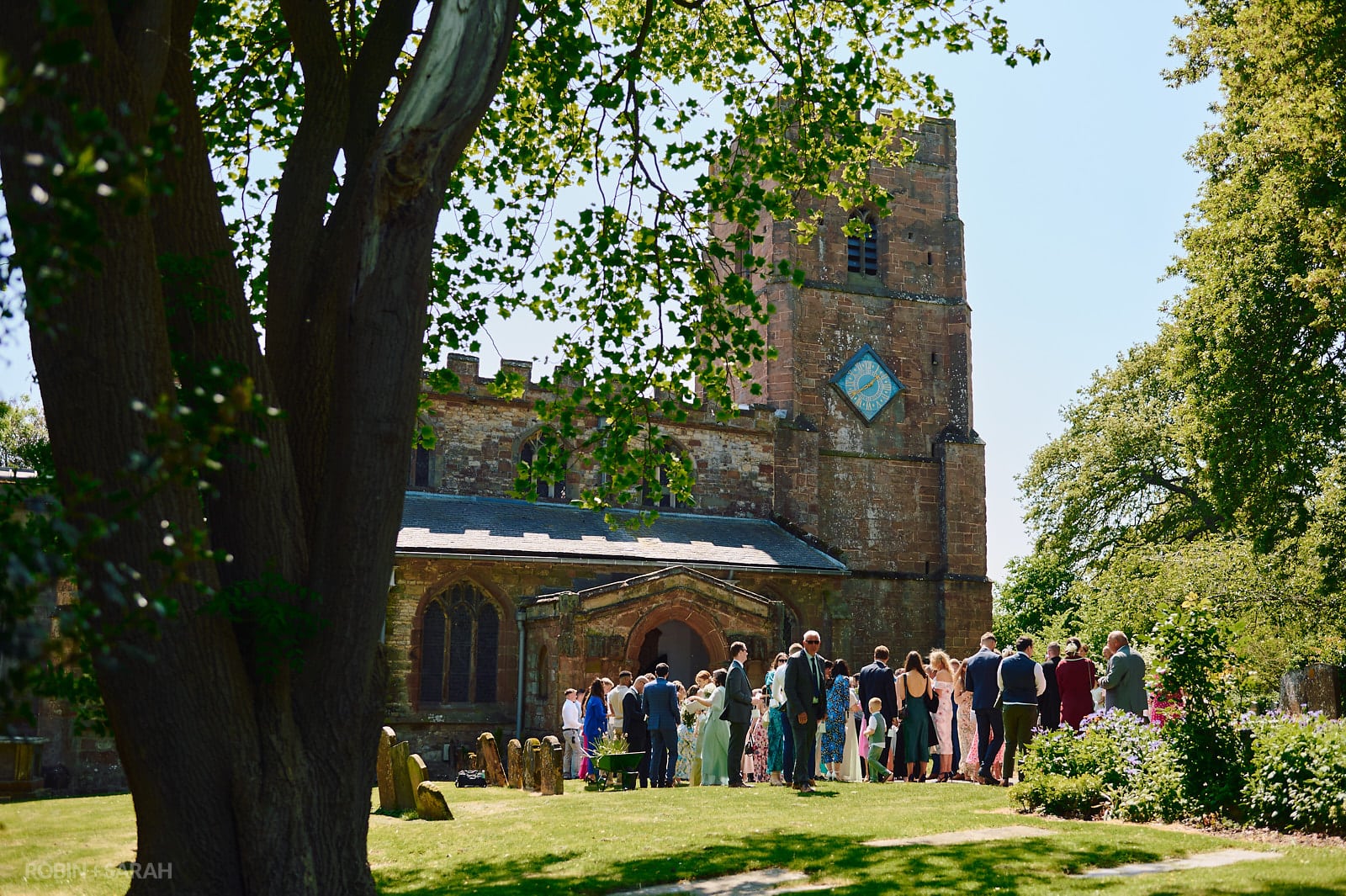 Guests congratulate bride and groom after wedding ceremony at St Botolph's church Newbold-on-Avon