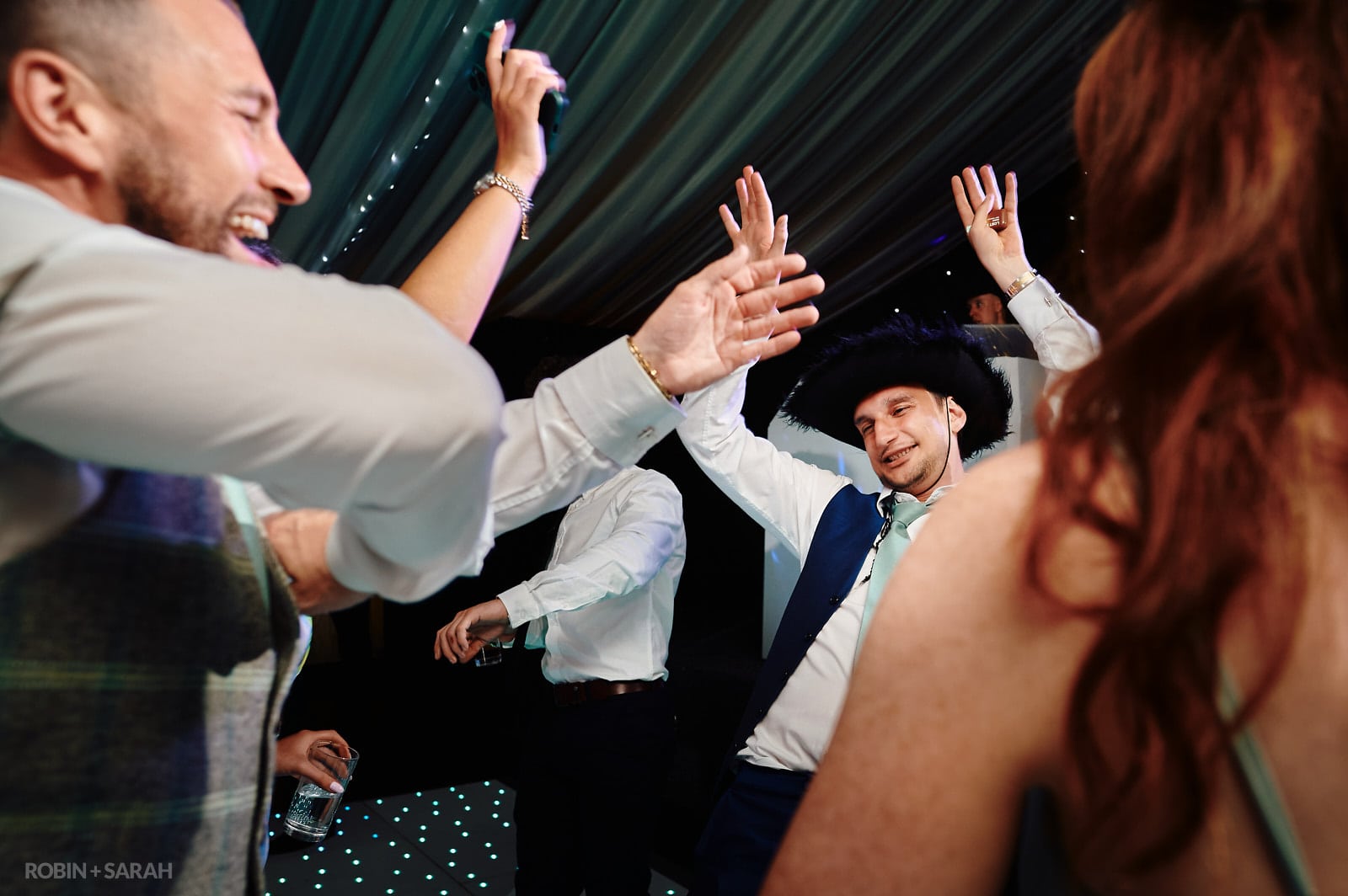 Guests dancing at wedding party held in marquee at Coombe Abbey
