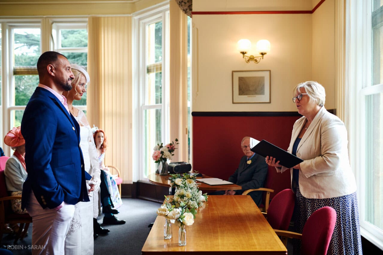 Bride and groom listen to officiant during wedding ceremony in The Elgar Room