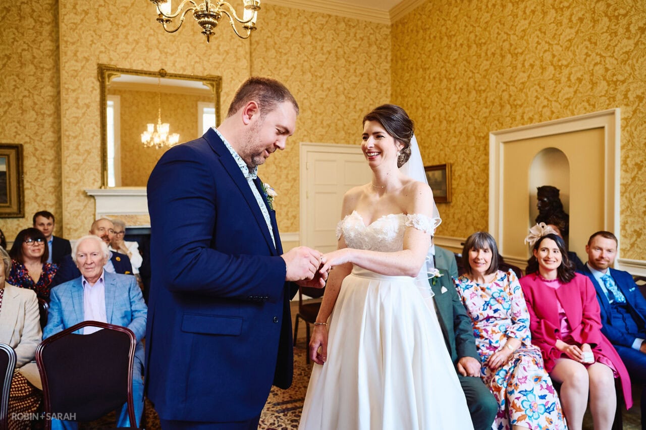 Bride and groom exchange wedding rings