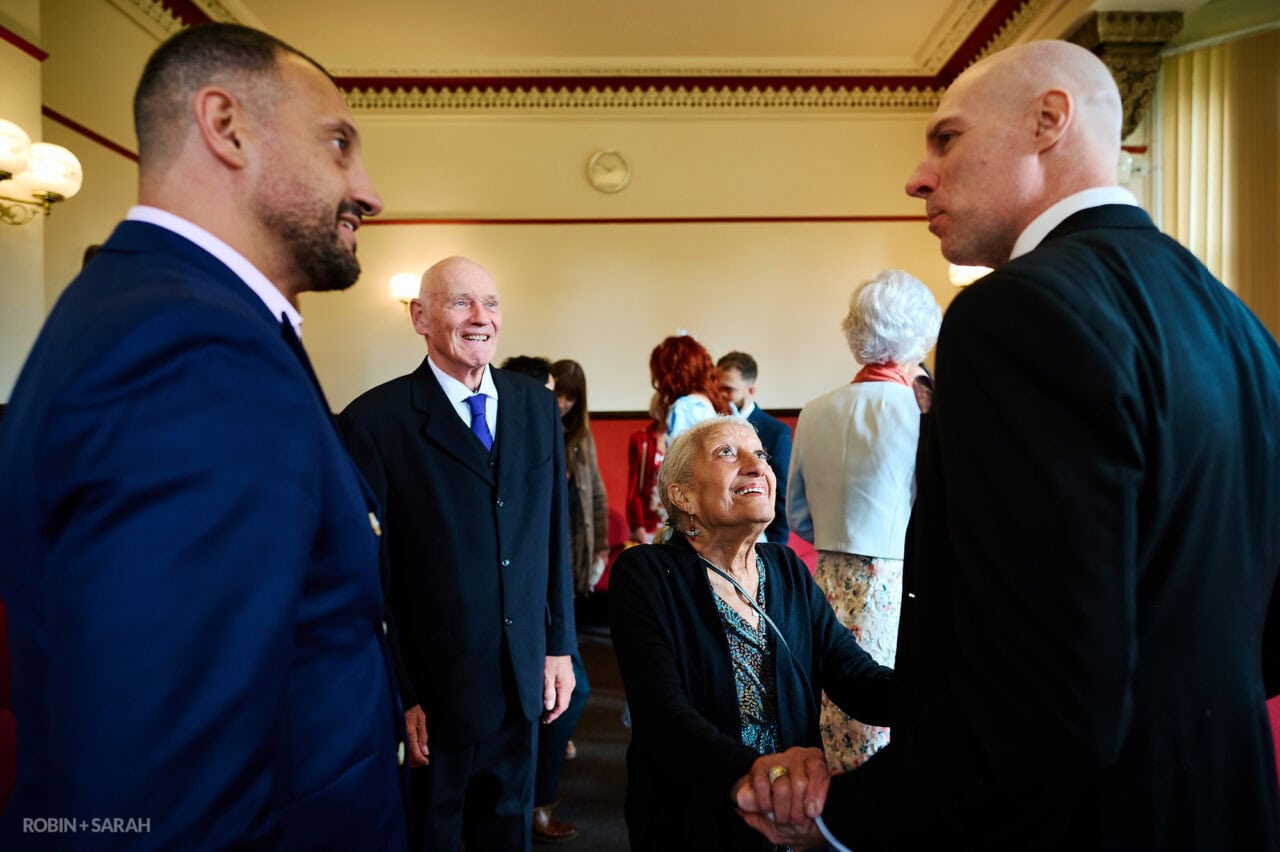 Wedding guests chat and relax before ceremony begins