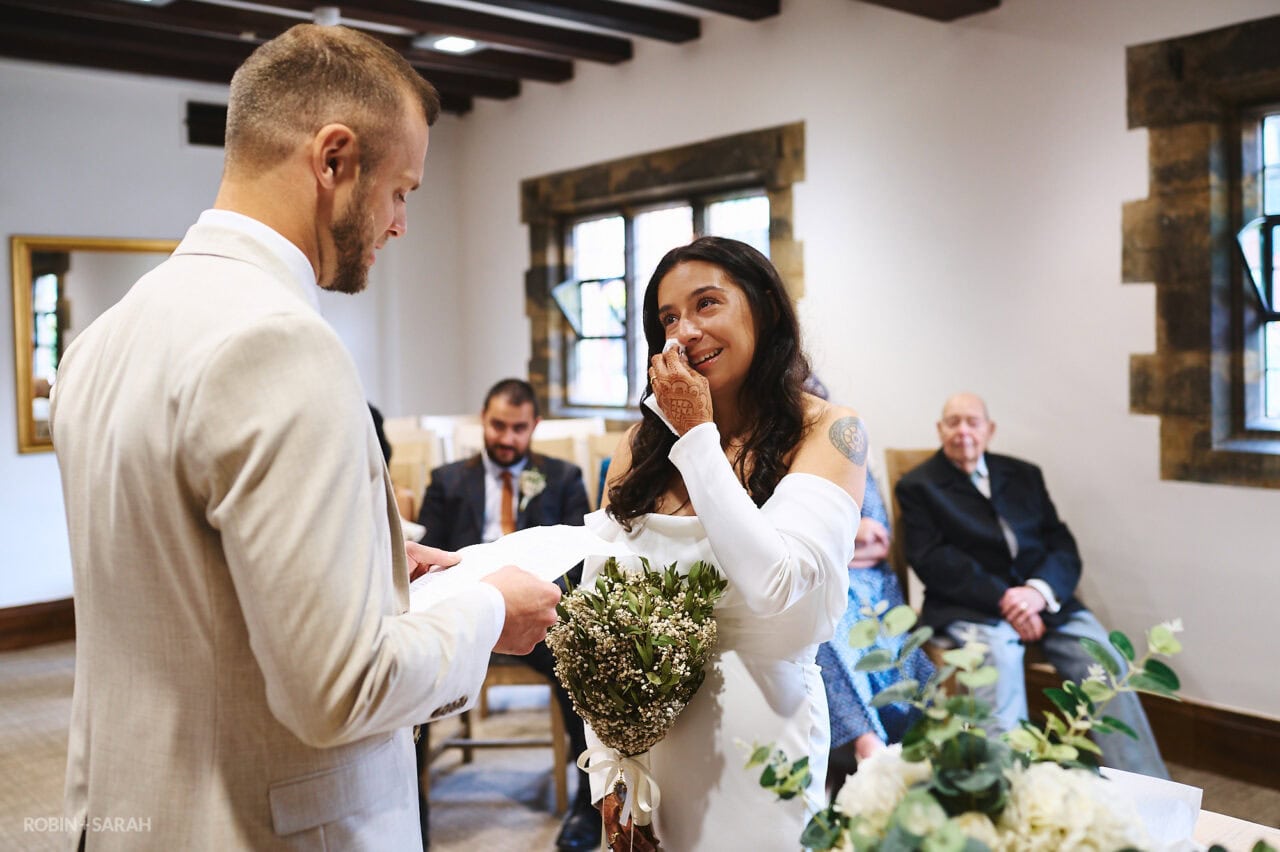 Bride wipes away tear during vow readings