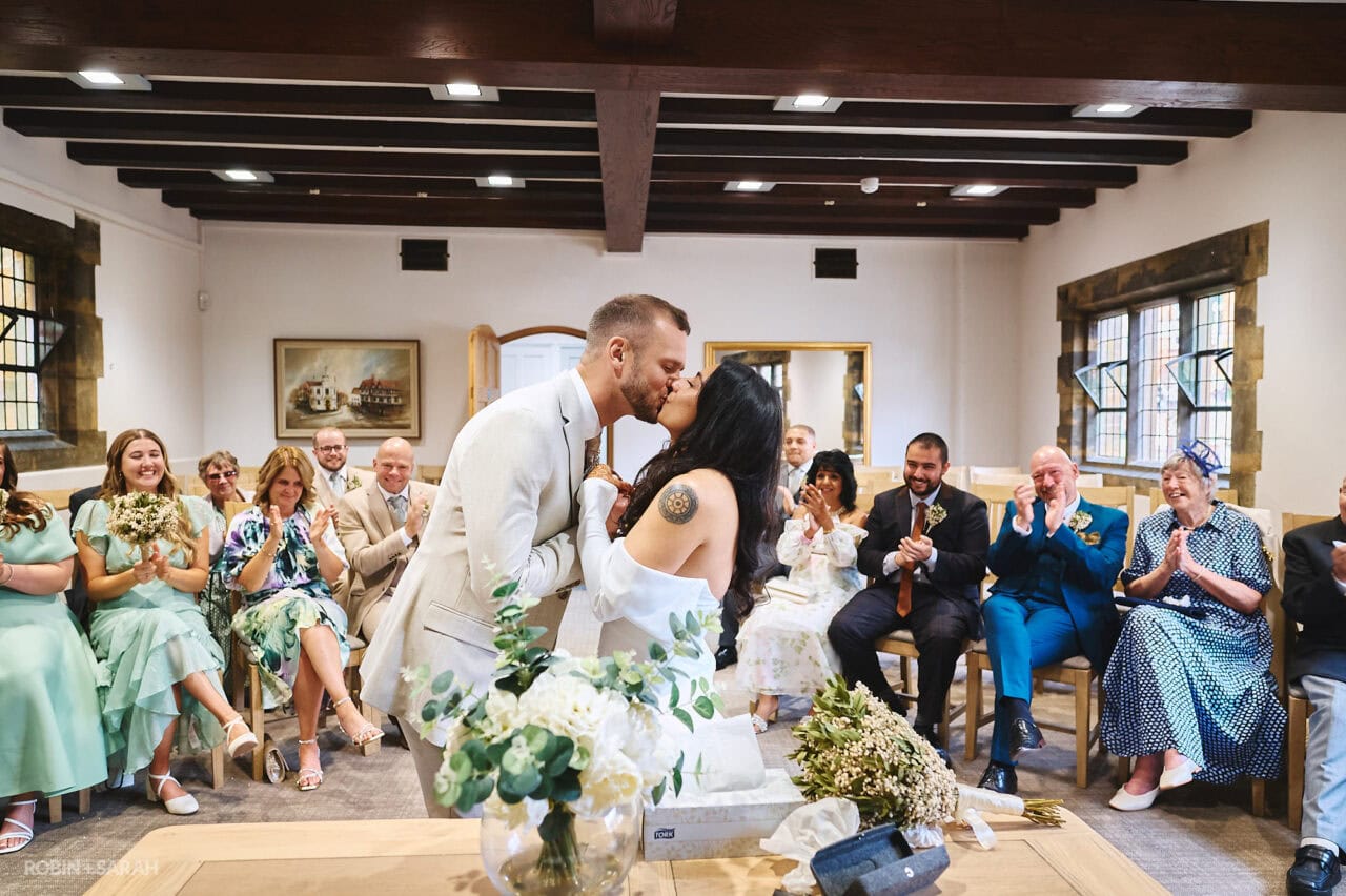 Bride and groom kiss at end of wedding ceremony