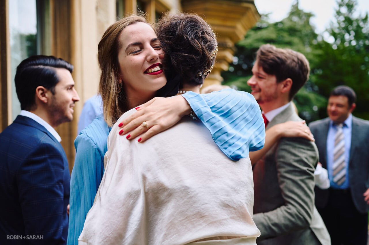 Wedding guest hugs bride after ceremony
