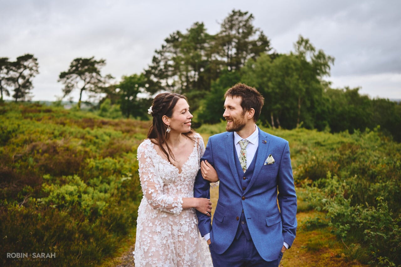 Bride and groom walking together in beautiful countryside