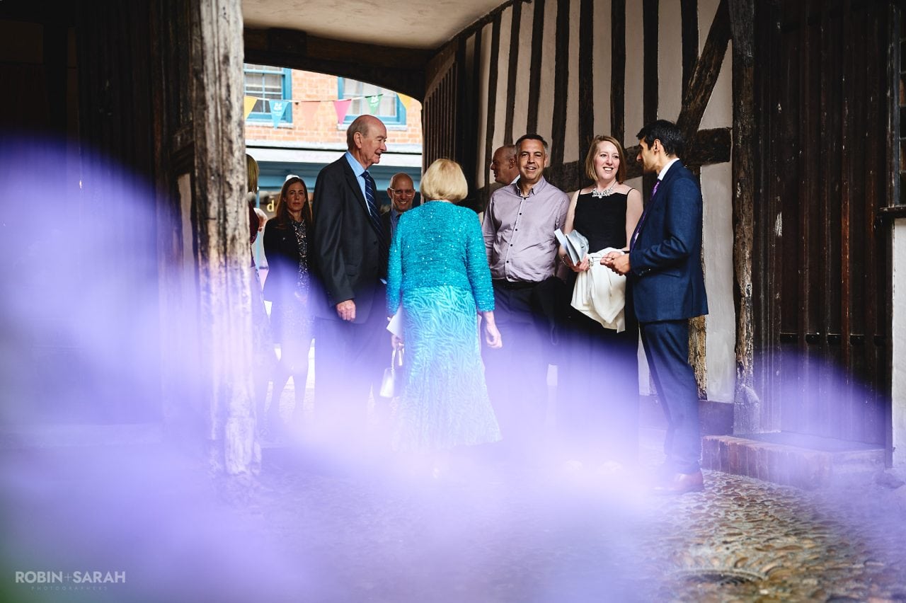 Wedding guests chat in entrance as they arrive at Greyfriars