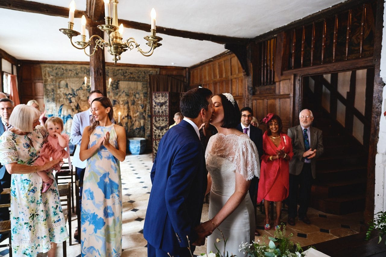 Bride and groom kiss at end of wedding ceremony