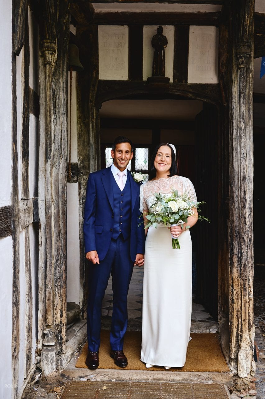 Bride and groom stand in doorway after wedding ceremony
