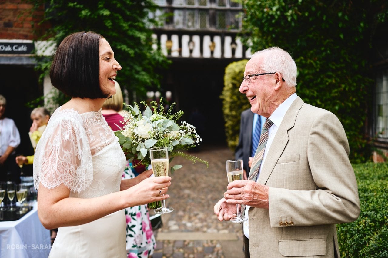 Bride and grandfather enjoy a laugh together after wedding ceremony