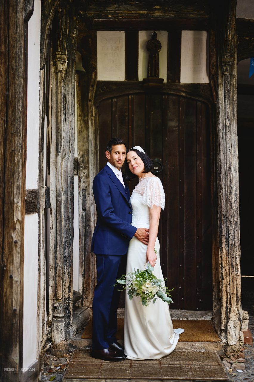 Bride and groom in doorway at Greyfriars Worcester, showing the beautiful old timbers of the building