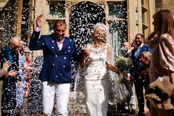 Lots of confetti thrown over newly married couple at a small wedding