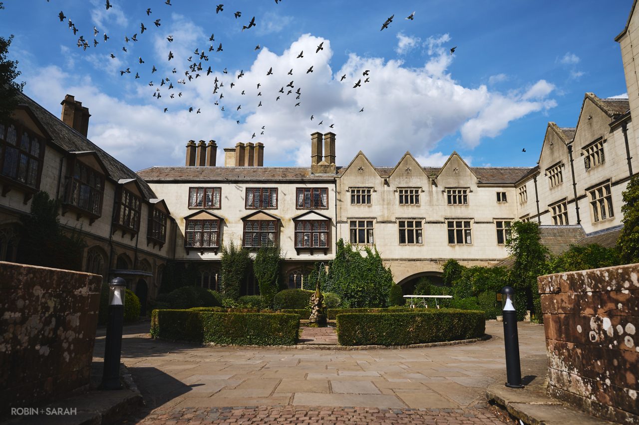 Exterior of Coombe Abbey Hotel showing main courtyard, with flock of birds flying past