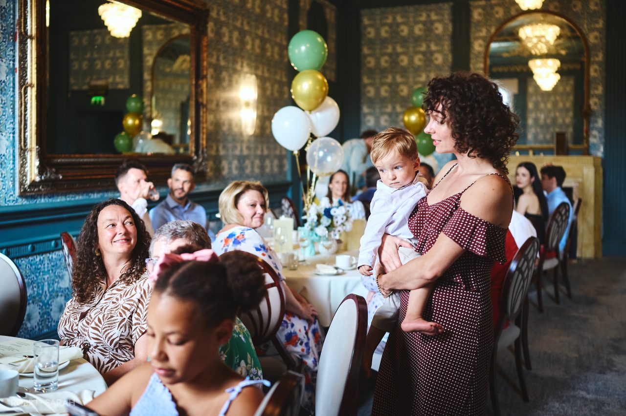 Mum an child chat to christening guests in Stuart room at Coombe Abbey