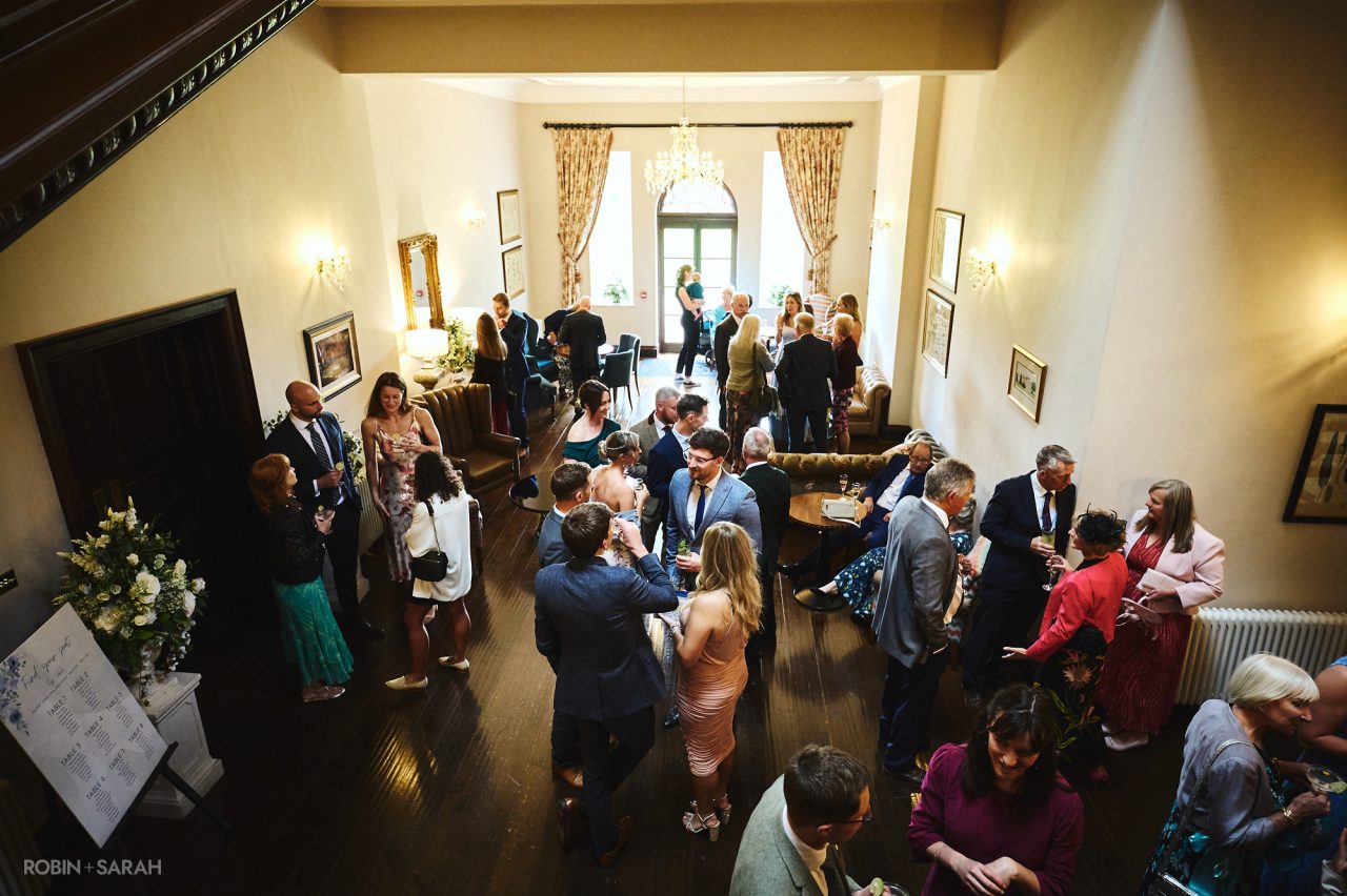 Guests enjoying drinks reception during wedding at Bourton Hall