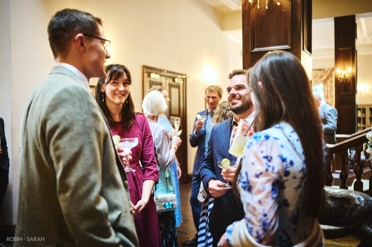 Wedding guests chatting during drinks reception at Bourton Hall