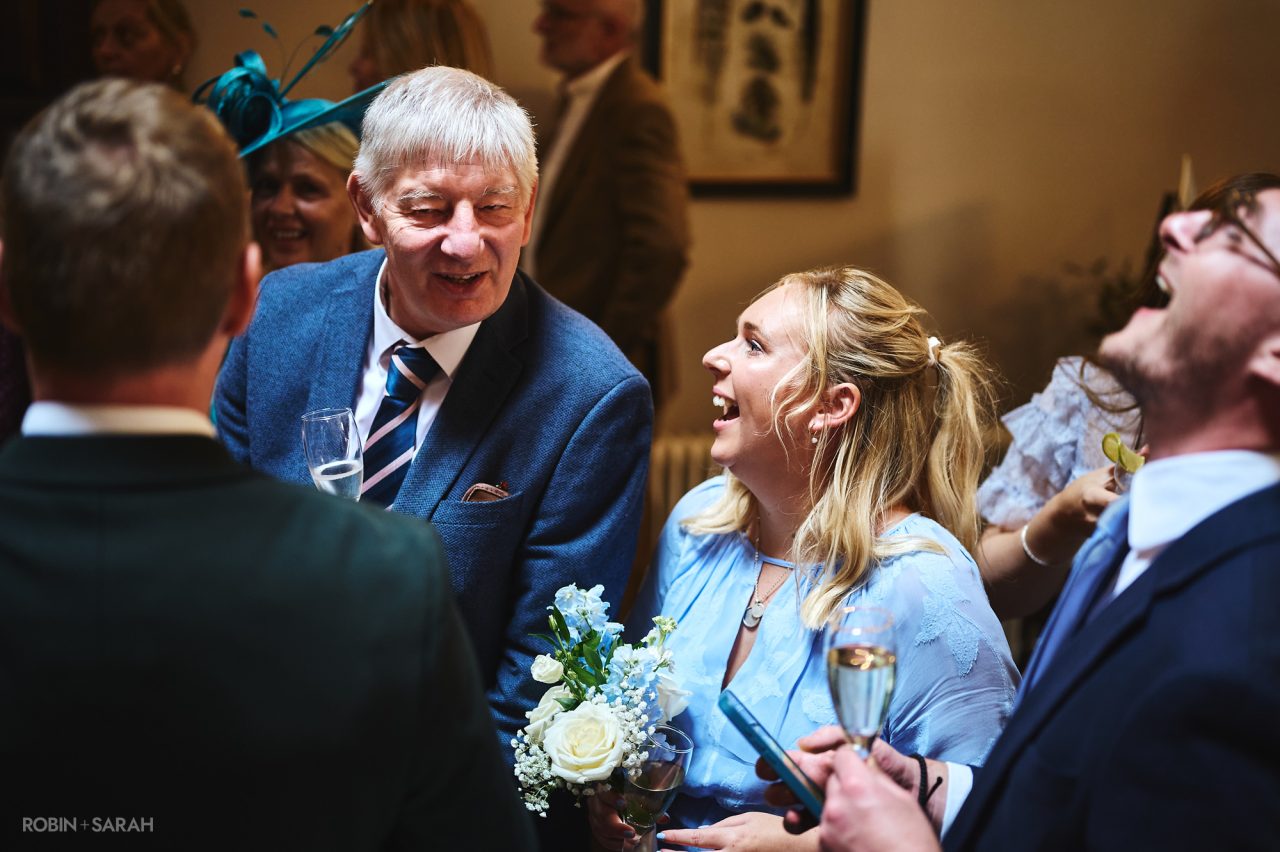 Wedding guests chat and relax during drinks reception