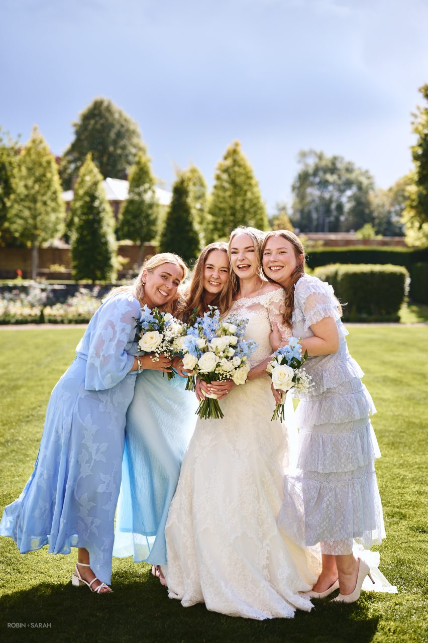 Bride and bridesmaids having fun on the lawn at Bourton Hall in Warwickshire on a sunny day