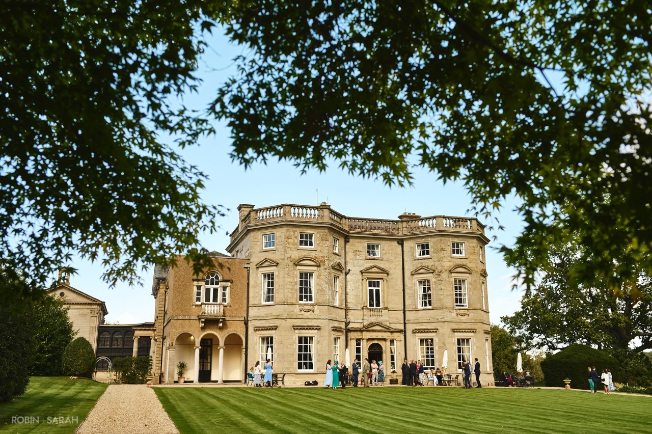 Wedding guests enjoying the drinks reception outside at Bourton Hall in Warwickshire
