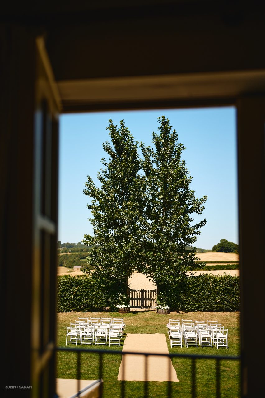 View from bedroom of Charingworth House looking out over the lawn with chairs set out for wedding ceremony