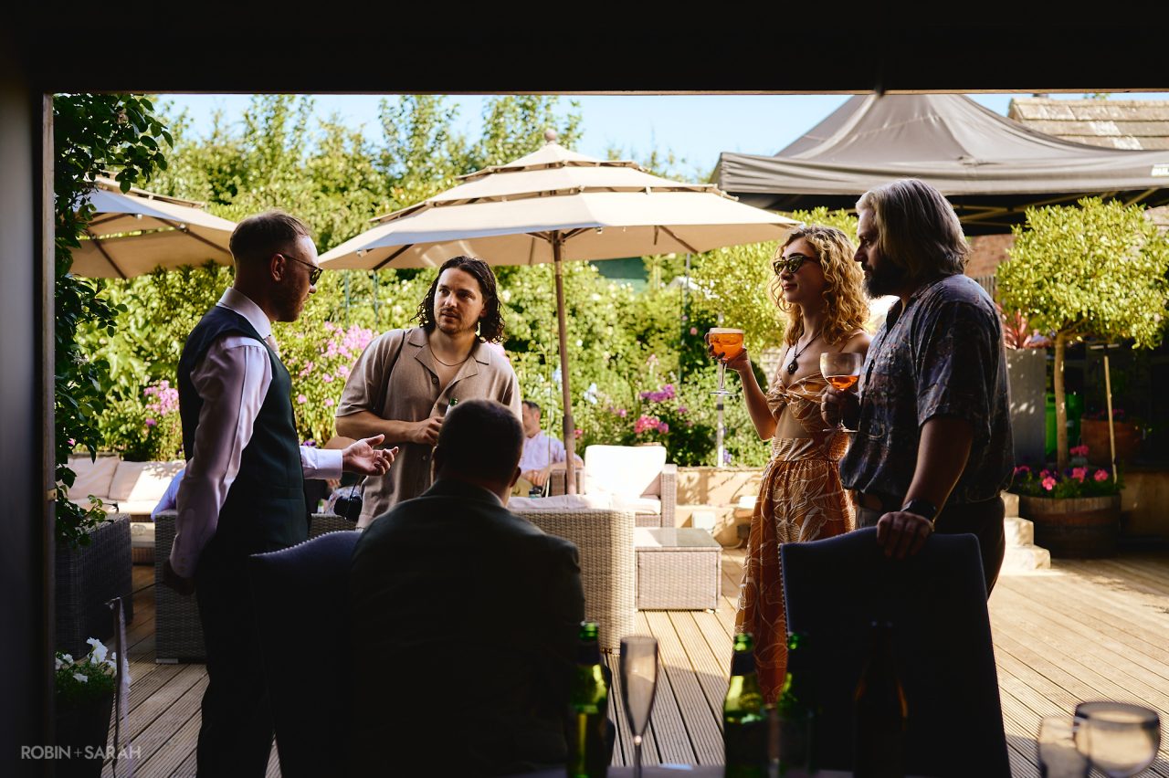 Wedding guests chat with groom at Charingworth House