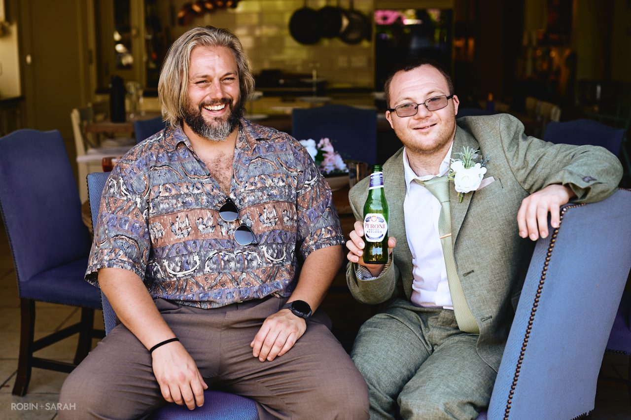 Two wedding guests enjoying a beer