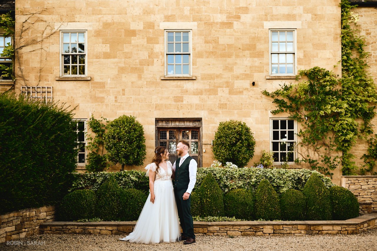 Bride and groom in front of Charingworth House during the early evening