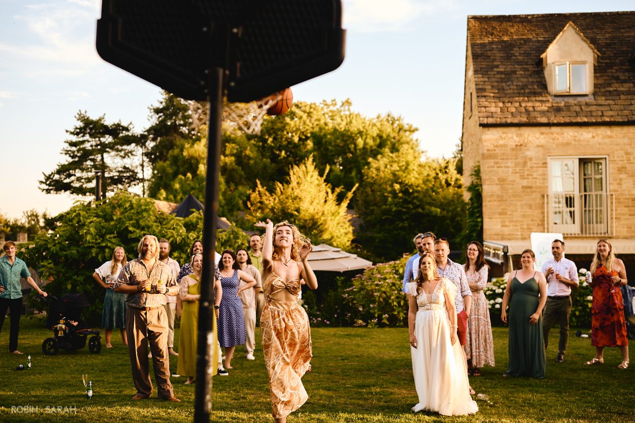 Wedding guests shoot basketball hoops during evening reception at Charingworth House