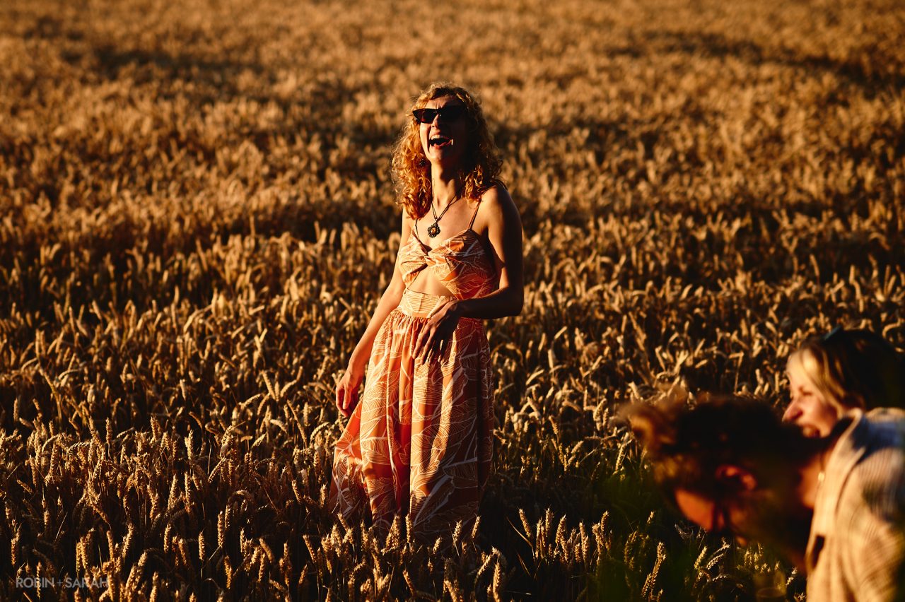 Wedding guest laughing in crop field
